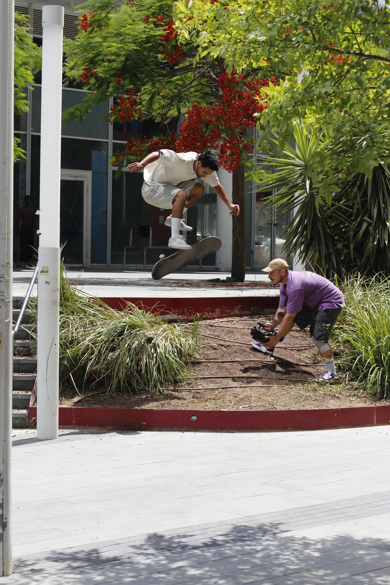 Filming a flip trick beside the trees